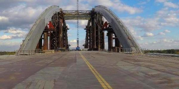 Подільський міст через Дніпро: на великій висоті скріплюють арку 