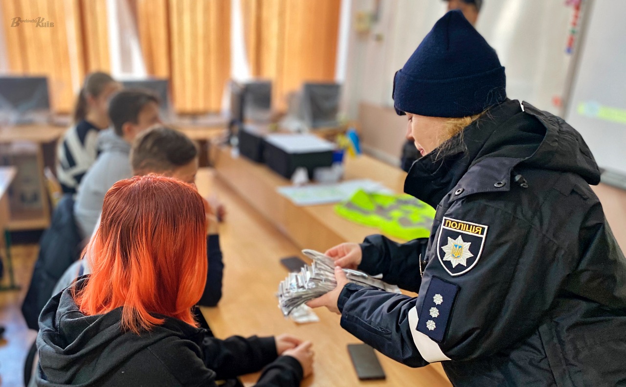 Учням роздають світловідбивальні стрічки. Фото: Даша Гришина