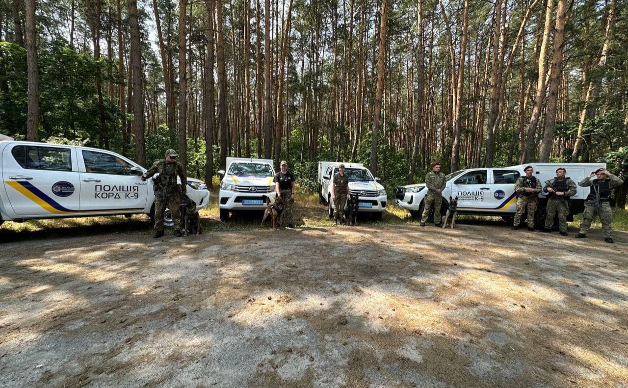 Поліцейські зі службовими собаками та авто для їх перевезення. Фото: Поліція Київської області