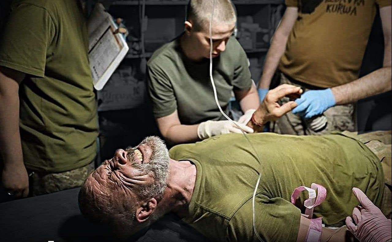 Бойові медики 5 окрема штурмова бригада рятують пораненого військового у пункті на околицях Бахмута. Фото: Олег Петрасюк