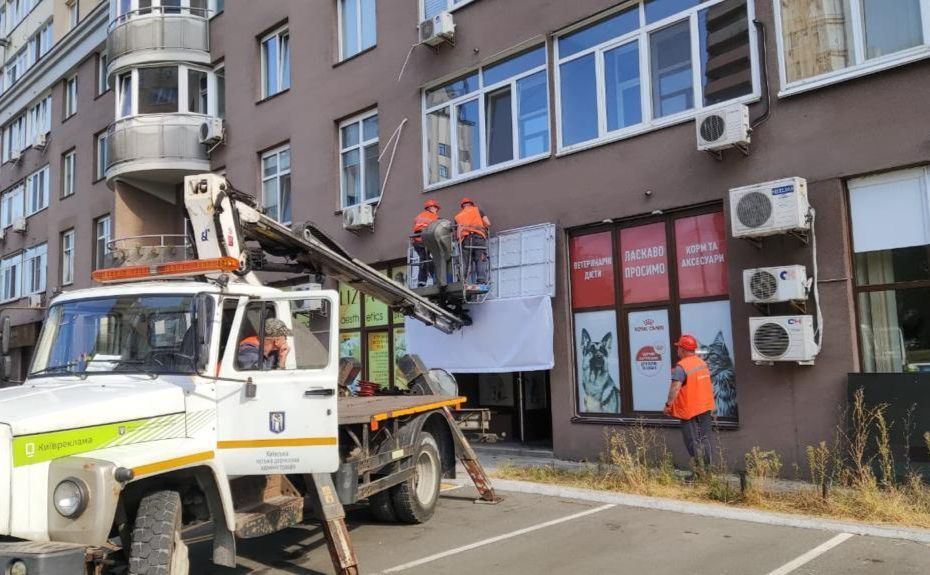Співробітники «Київреклама» демонтують незаконні рекламні вивіски. Фото: КМДА