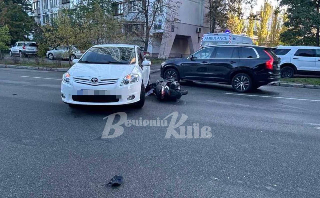 Чорну та білку автівку за одне ДТП пошкодив мотоцикліст. Фото: «Вечірній Київ»