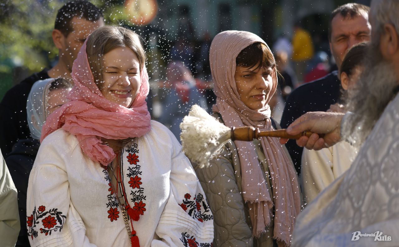 Священник звершує обряд освячення великодніх кошиків, благословляючи вірян святою водою. Фото: Борис Корпусенко
