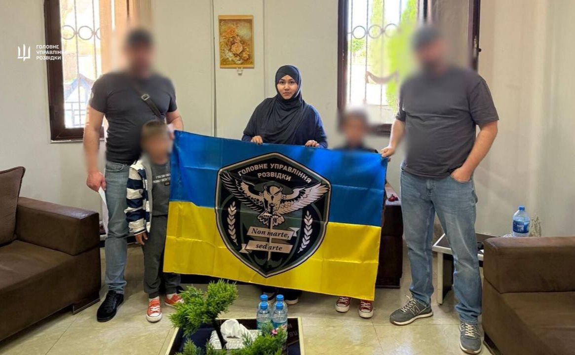 Мама з дітьми тримає прапор України. Фото: ГУР