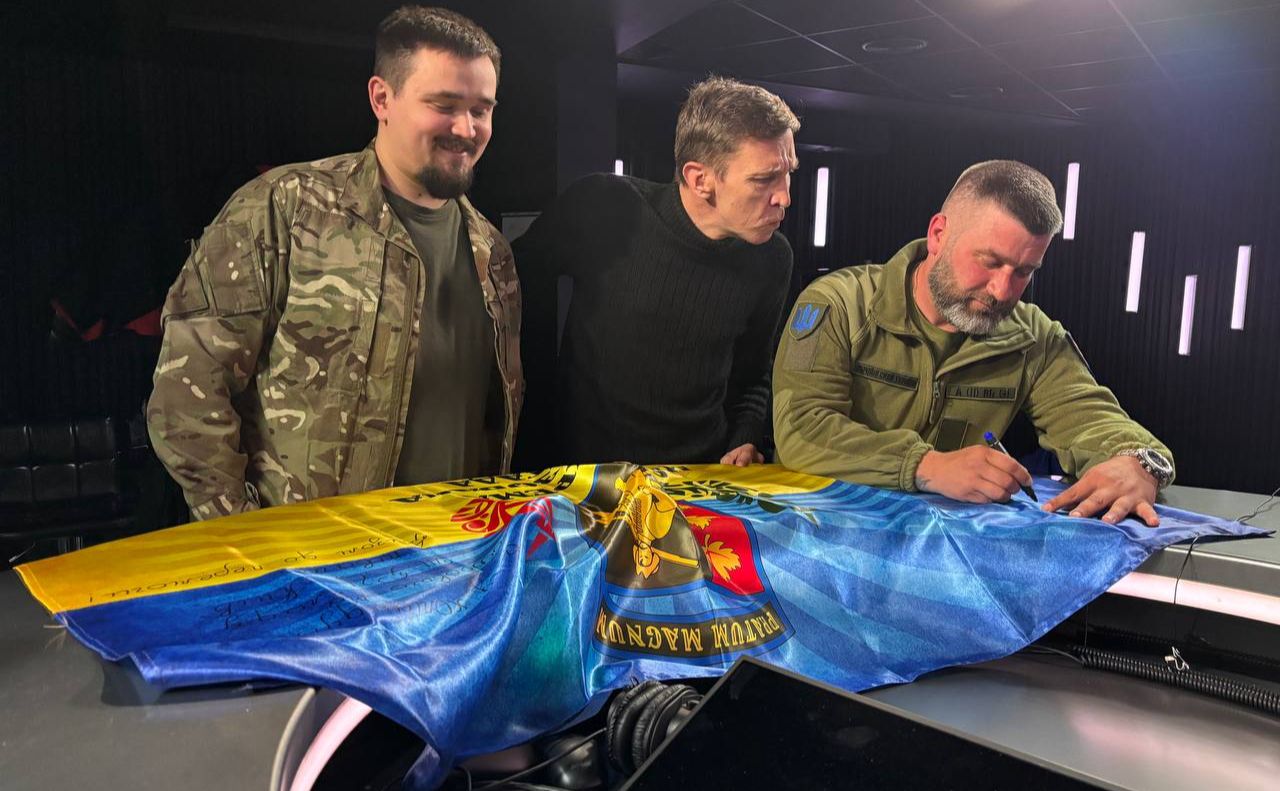 Бійці подарували журналістам у студію прапор бригади. Фото: 65 ОМБ