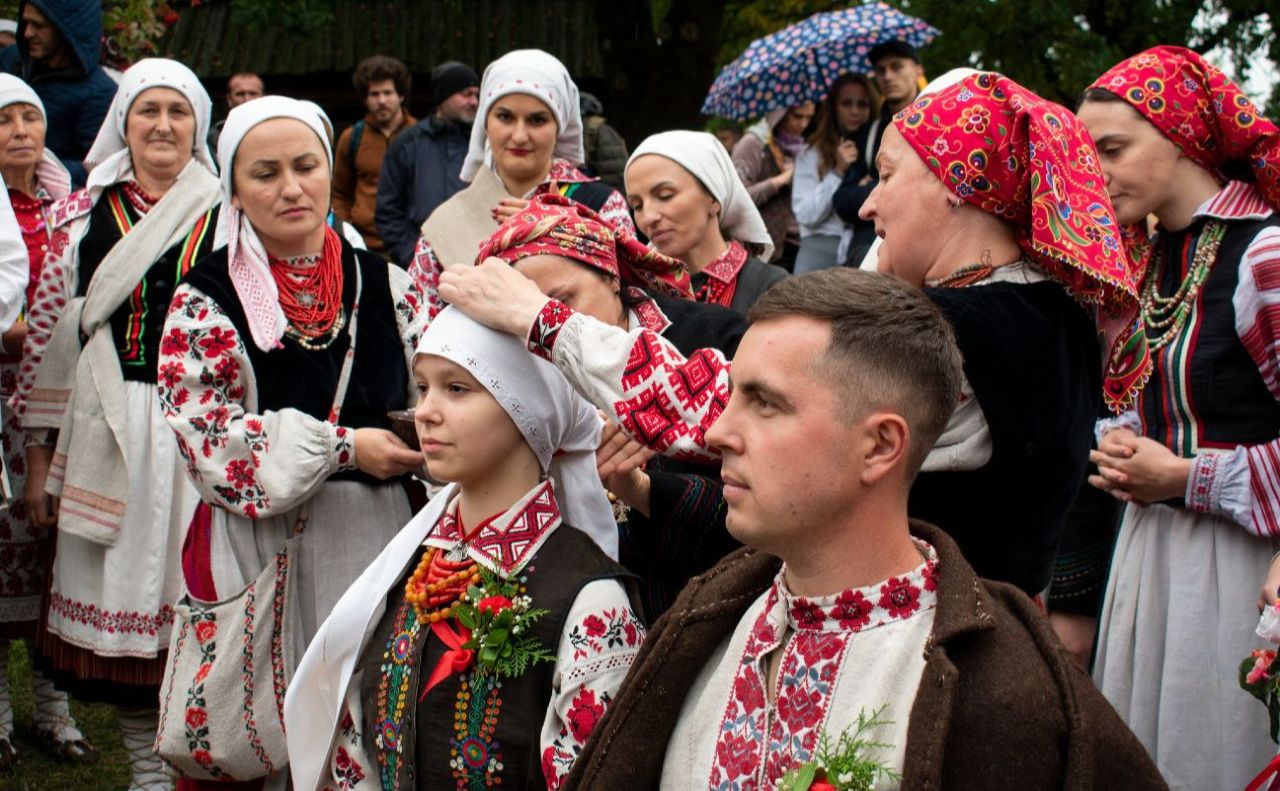 Нареченій пов’язують голову хусткою. Фото: НМНАПУ