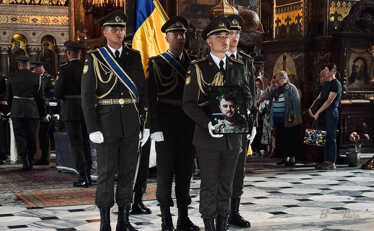 Військові тримають світлину Євгена «Остапа» Остапенка під час відспівування у Володимирському соборі у Києві. Фото: Анна Білоус