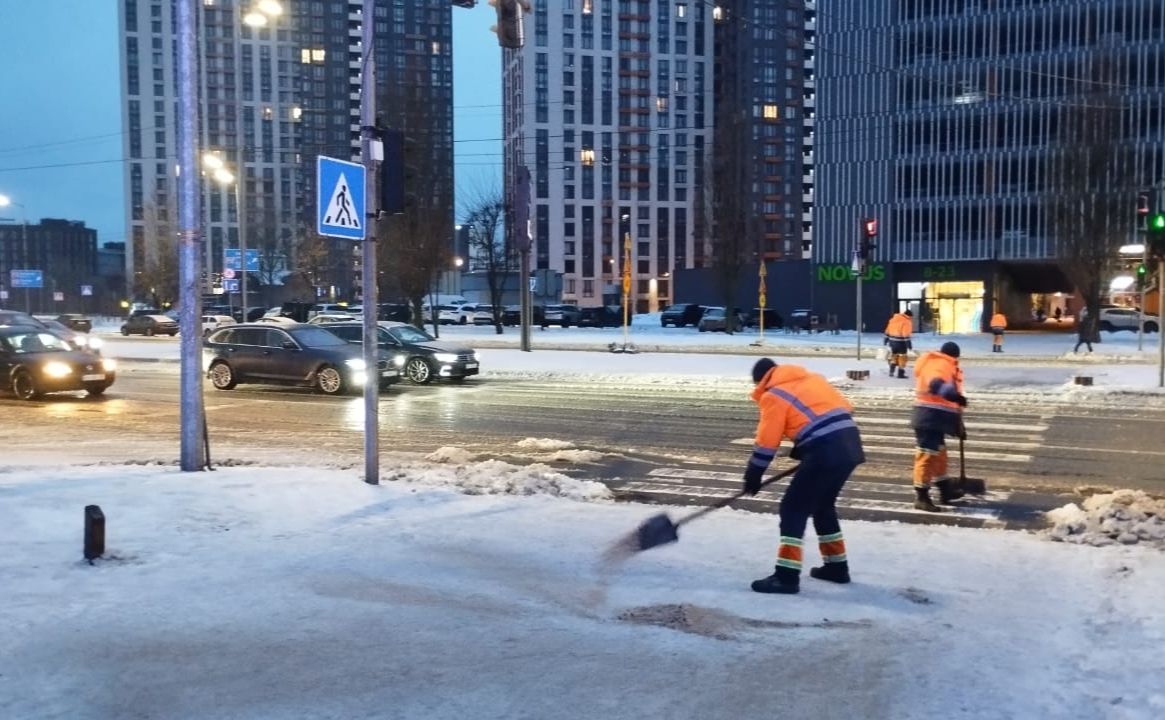 Робітники посипають тротуари піском та сіллю. Фото: Дарницька РДА