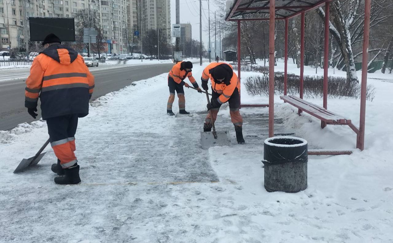 Комунальники чистять кригу на зупинці транспорту. Фото: КМДА
