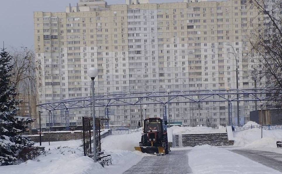 Трактор чистити дорогу біля багатоповерхівки у Києві. Фото: КМДА