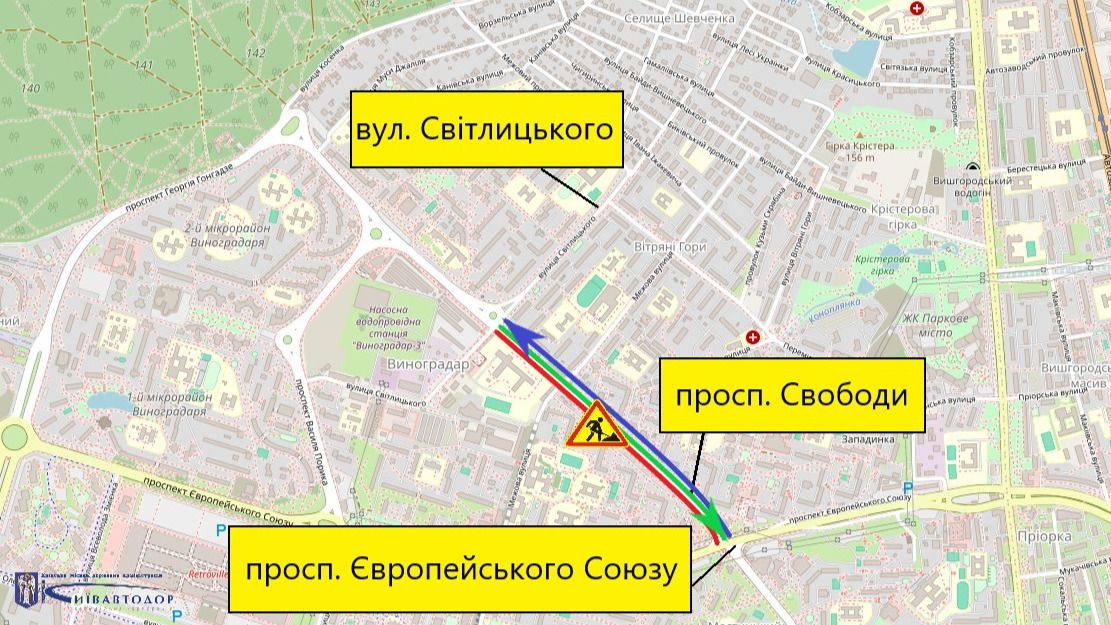 Схема обмеження руху на проспекті Свободи в Києві. На карті показана ділянка дороги між вулицею Світлицького та проспектом Європейського Союзу. У центрі схеми позначено проспект Свободи, де проводяться дорожні роботи (попереджувальний знак із робітником). Стрілками різних кольорів показані напрямки руху транспорту цією ділянкою. На карті також підписані основні орієнтири: вулиця Світлицького, проспект Свободи та проспект Європейського Союзу. По краях зображення розміщені жовто-чорні смуги, що позначають зону ремонтних робіт.