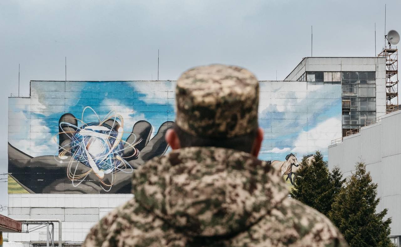 Військовослужбовець 28 Чорнобильського полку НГУ дивиться на будівлю ЧАЕС. Фото: МВС