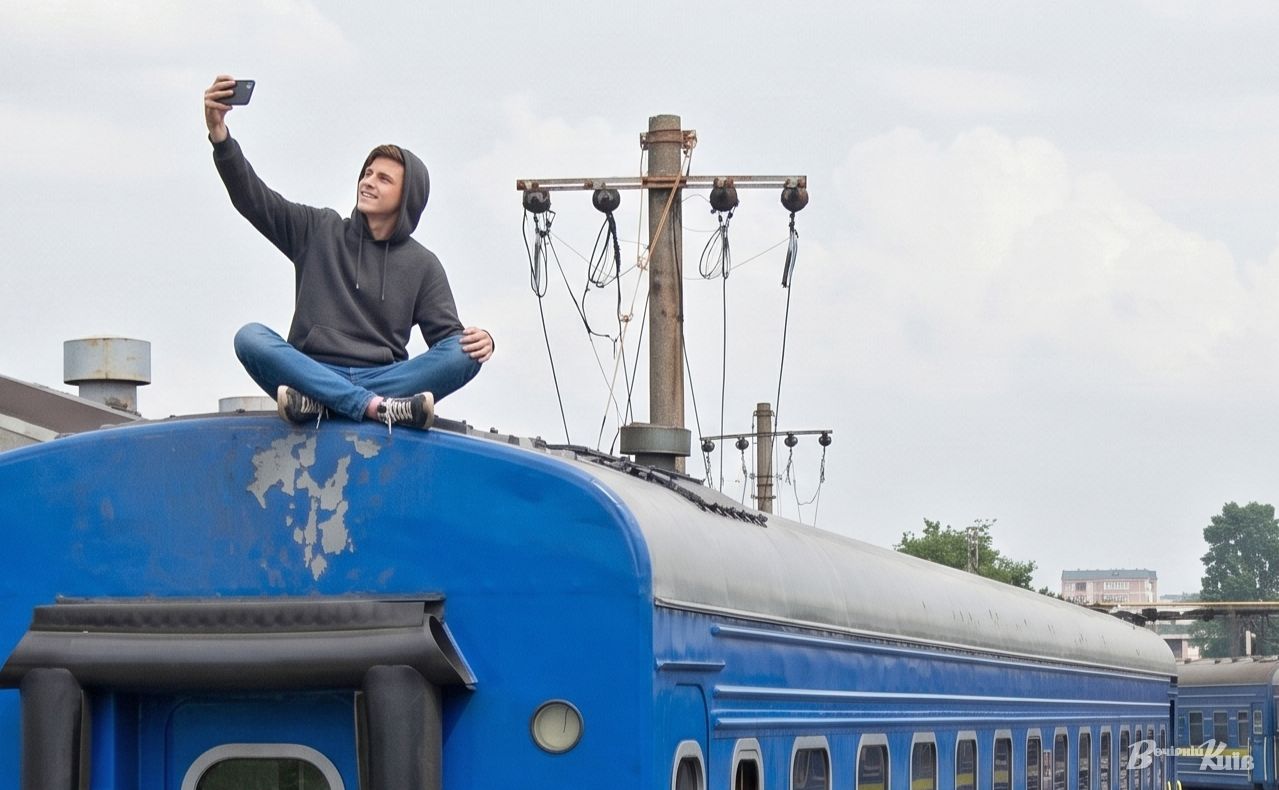 Екстремальні селфі на дахах вагонів дедалі частіше закінчуються трагедією. Ілюстрація для «Вечірнього Києва» створена за допомогою ШІ