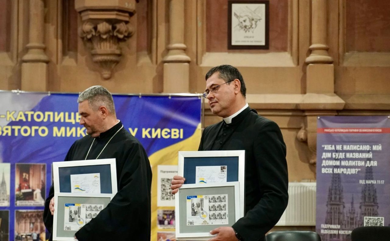 Настоятель парафії о. Павло Вишковський ОМІ демонструє присутнім ювілейний поштовий знак, присвячений річниці візиту Понтифіка.Фото: Олександра Ходаковаська зі сторінки парафії